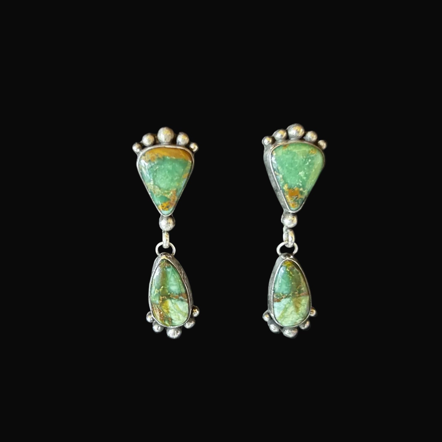 Pair of turquoise teardrop earrings on a black background